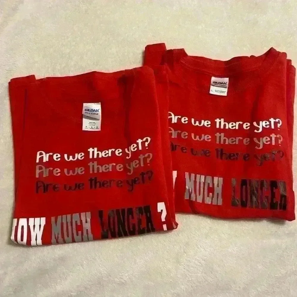 2 Boys T shirts in red ARE WE THERE YET HOW MUCH LONGER sizes Medium & Large.